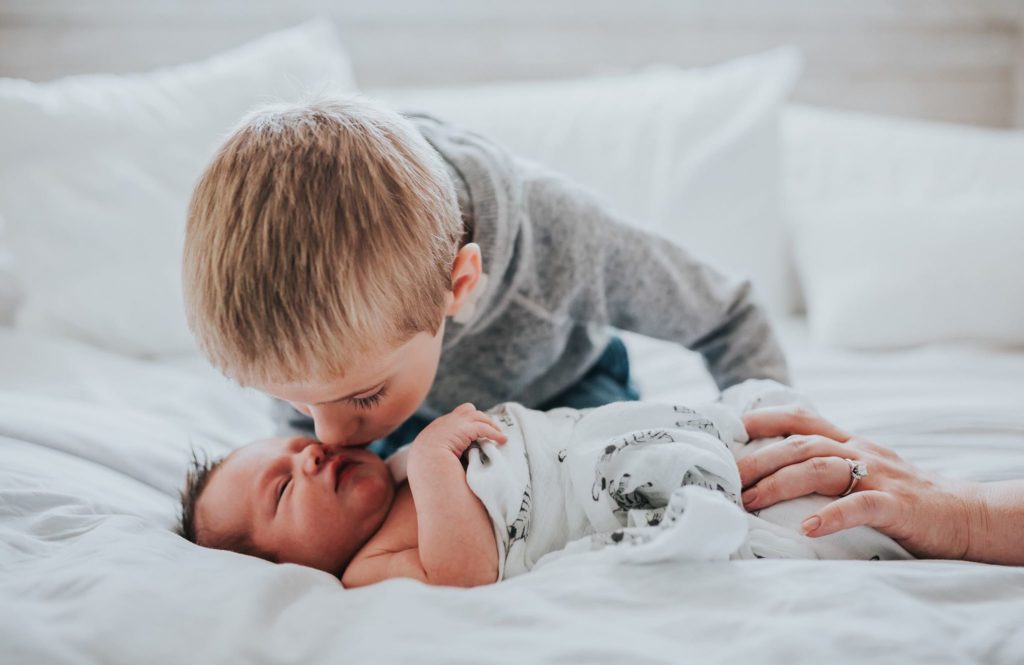 little boy kissing a baby