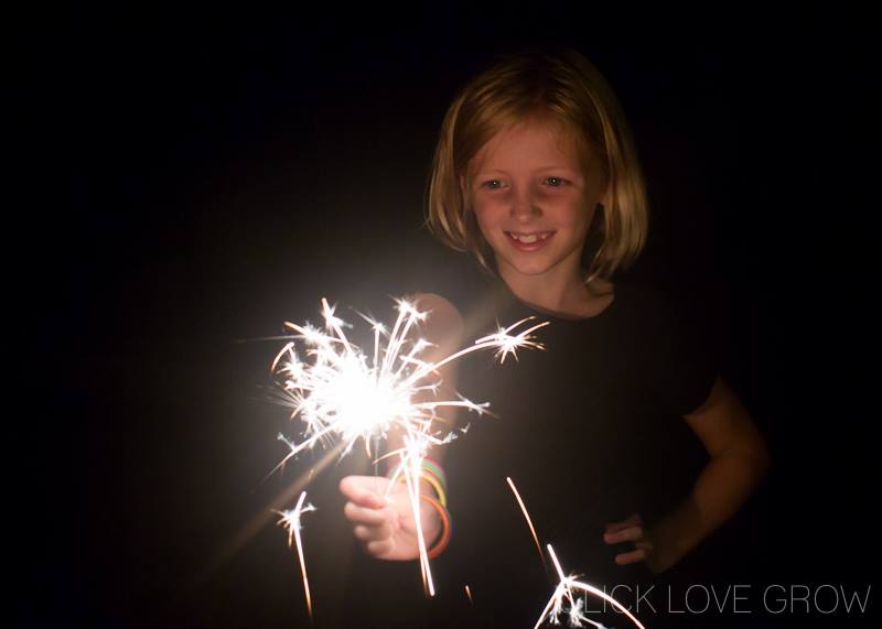 little girl learning how to take sparkler pictures