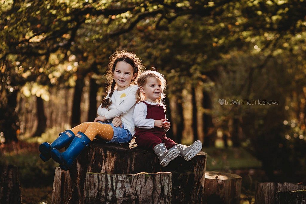 bokeh light photos of two young girls in the forest