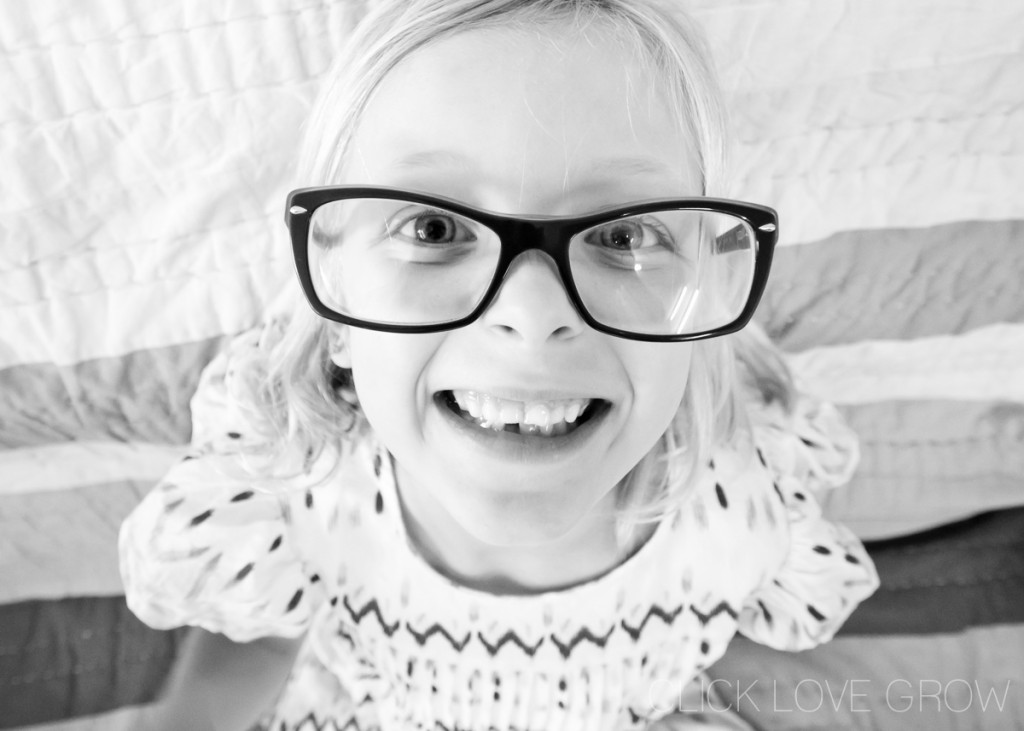 little girl with glasses smiling creating background blur