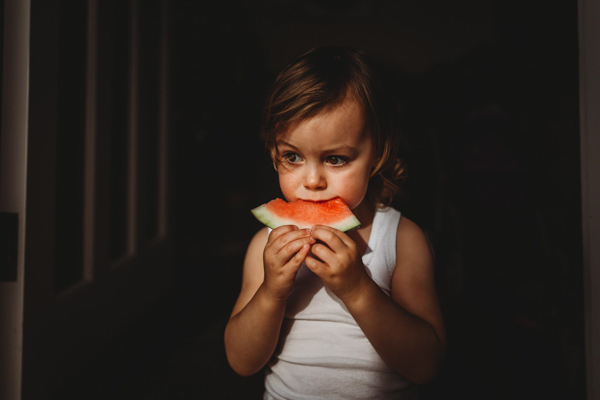 little girl eating a watermelon