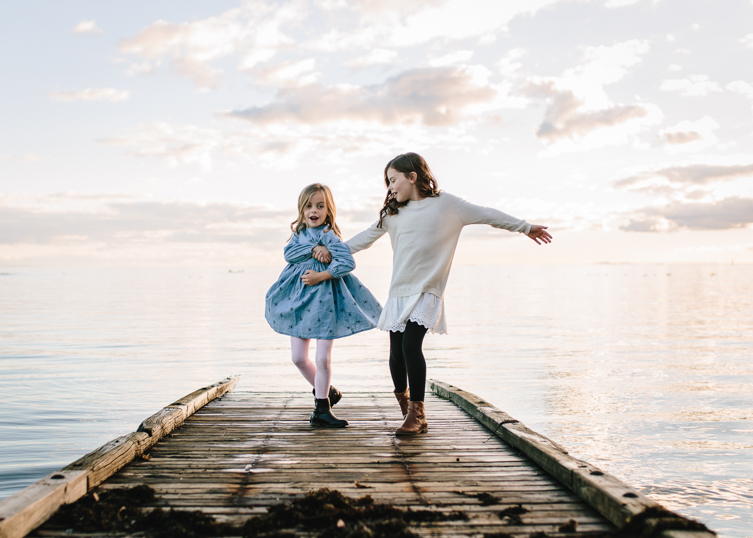  little girls having fun by the water during golden hour photography