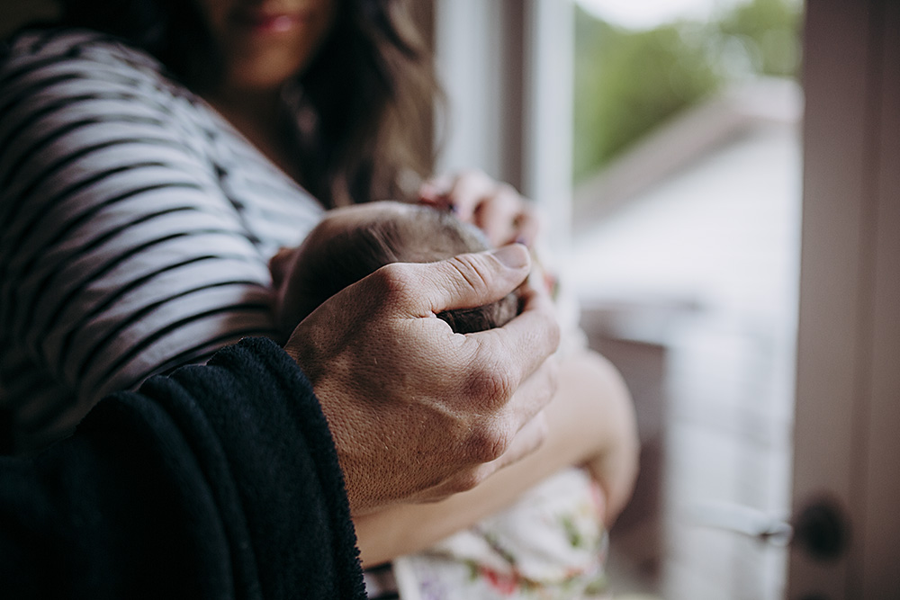 natural light lifestyle pictures of parents holding newborn baby
