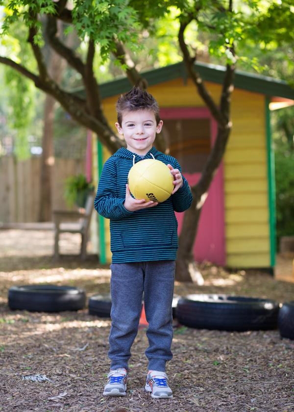 preschool boy holding yellow ball