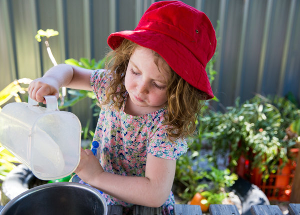 preschool girl watering flowers