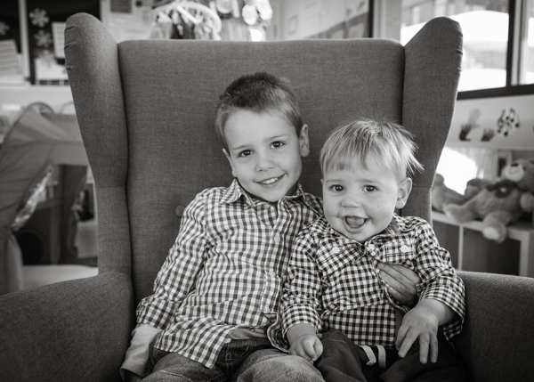 two little boys on a chair smiling