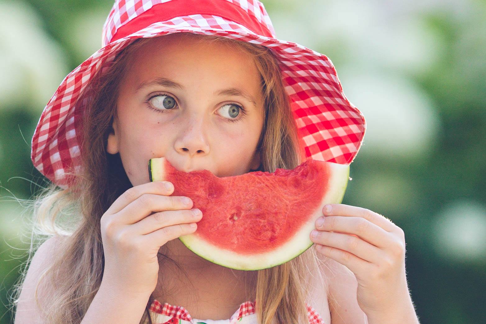 young girl eating a watermelon