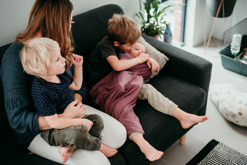mother with children and newborn on the couch