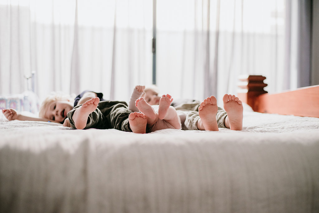 kids in bed for for a newborn photography session