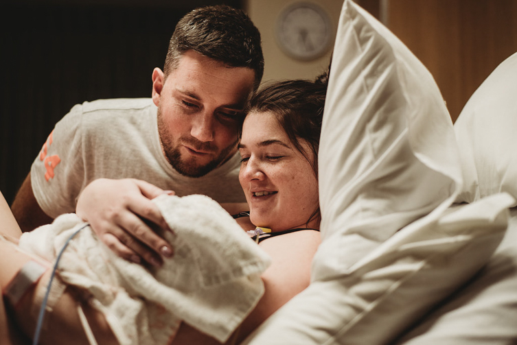 couple looking at baby during birth photography