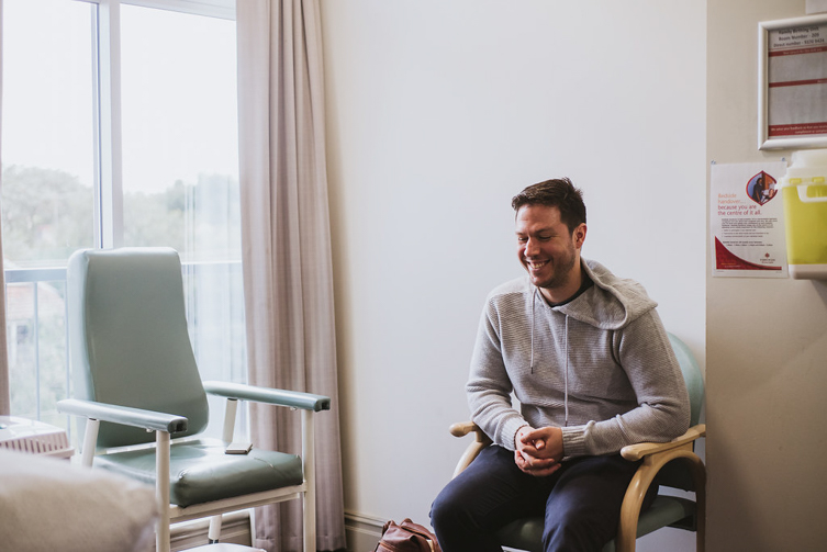 photograph of man smiling in hospital room