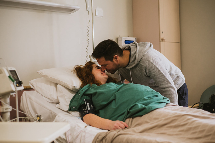 man kissing his wife before c-section surgery