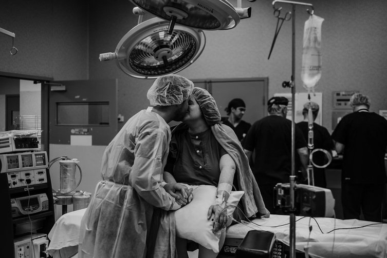 couple kissing before cesarean surgery