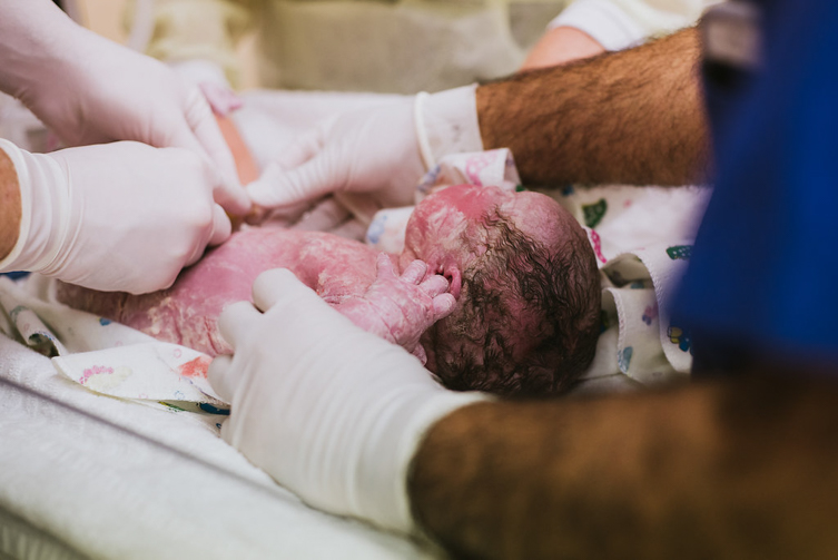 doctors with newborn baby