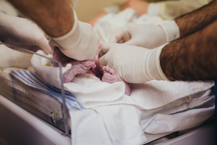 doctors handling newborn baby