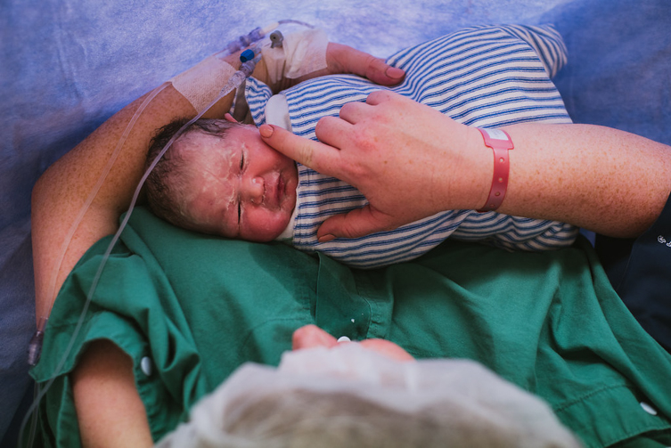 birth photography session of woman touching newborn’s face