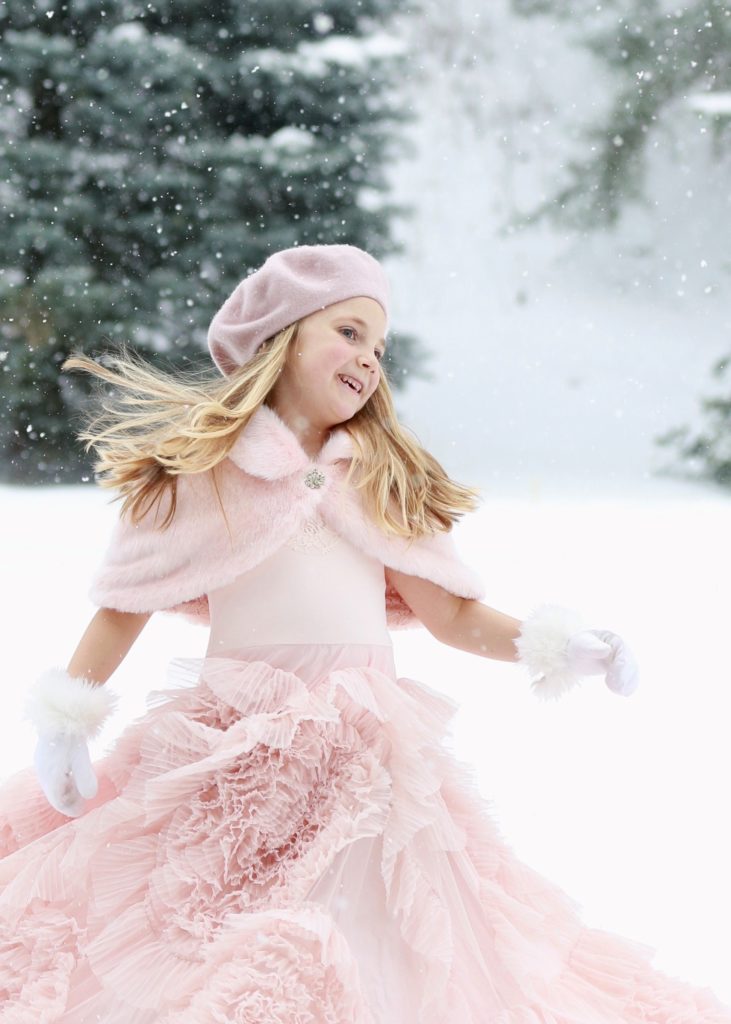 portraits of girl dressed in pink in the snow