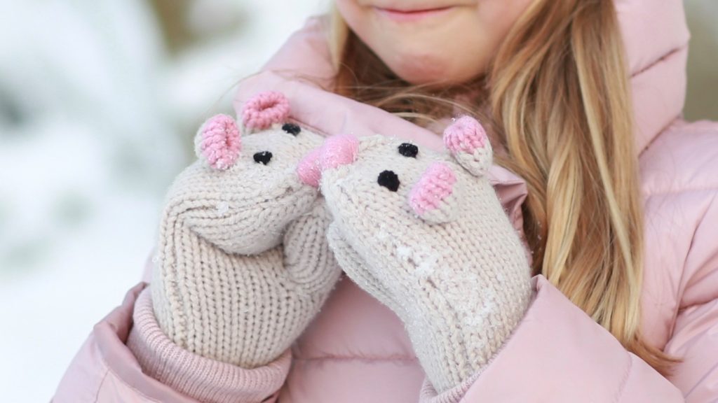 taking snow images of girl wearing knitted gloves