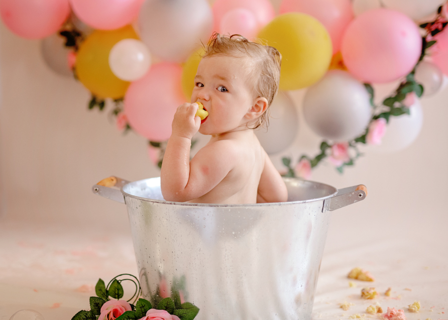 baby in bucket eating cake in cake smash photo