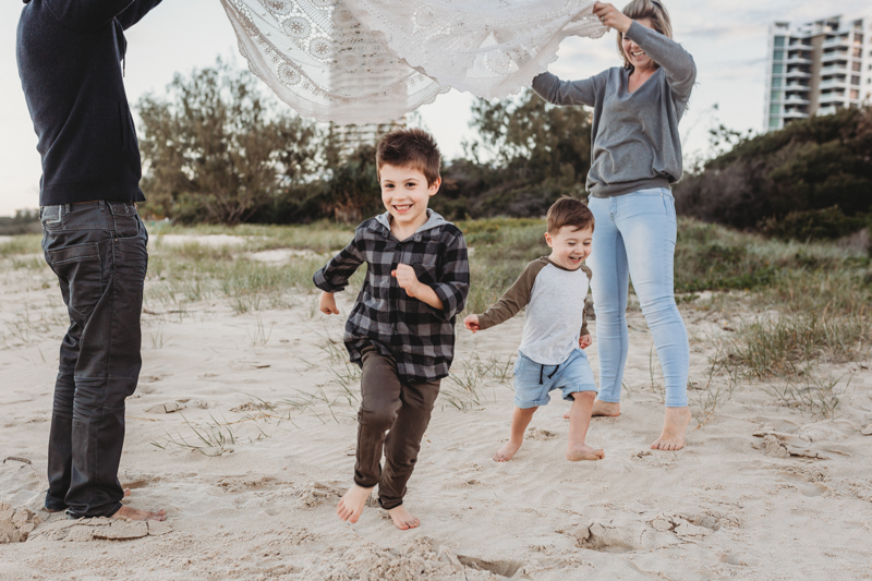 lifestyle vs. portrait photography of family playing at the beach