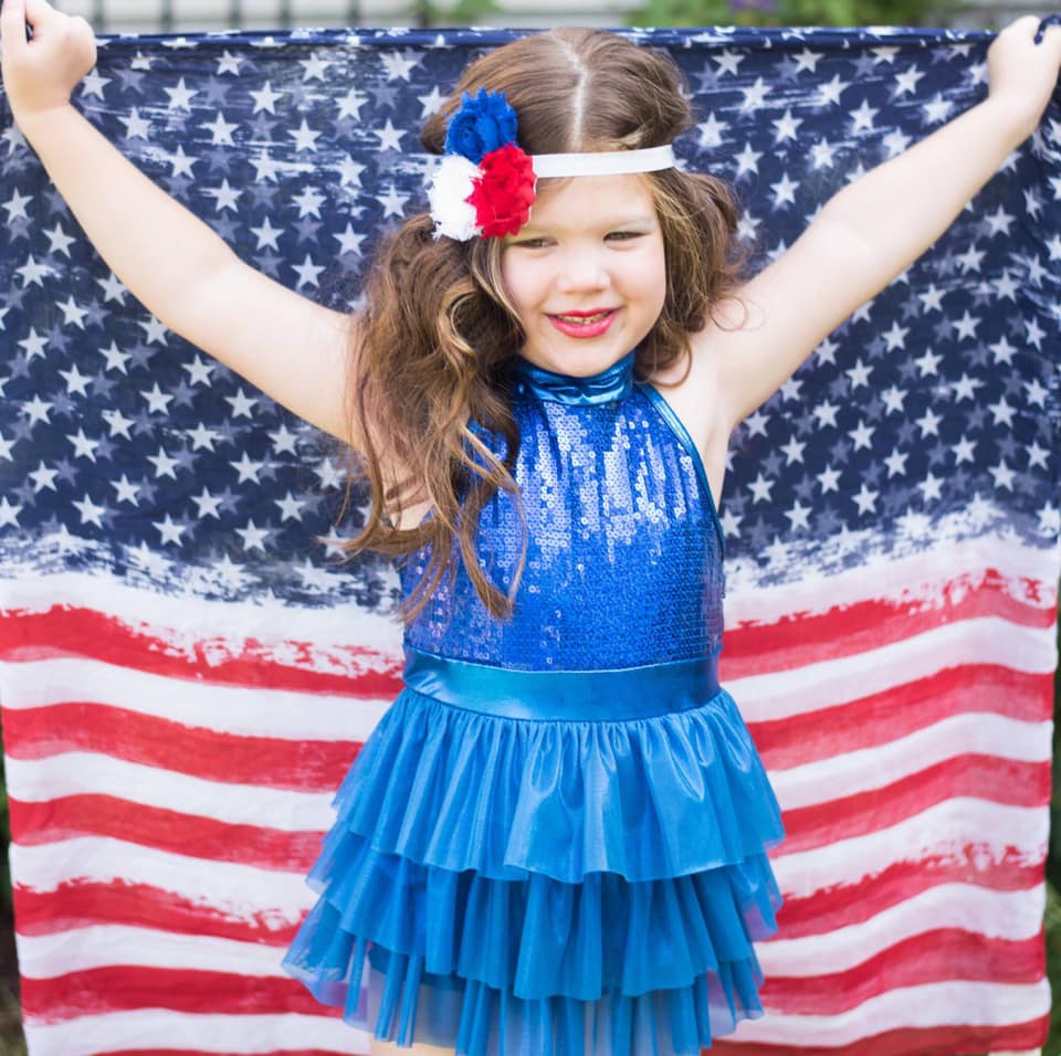 little girl holding american flag