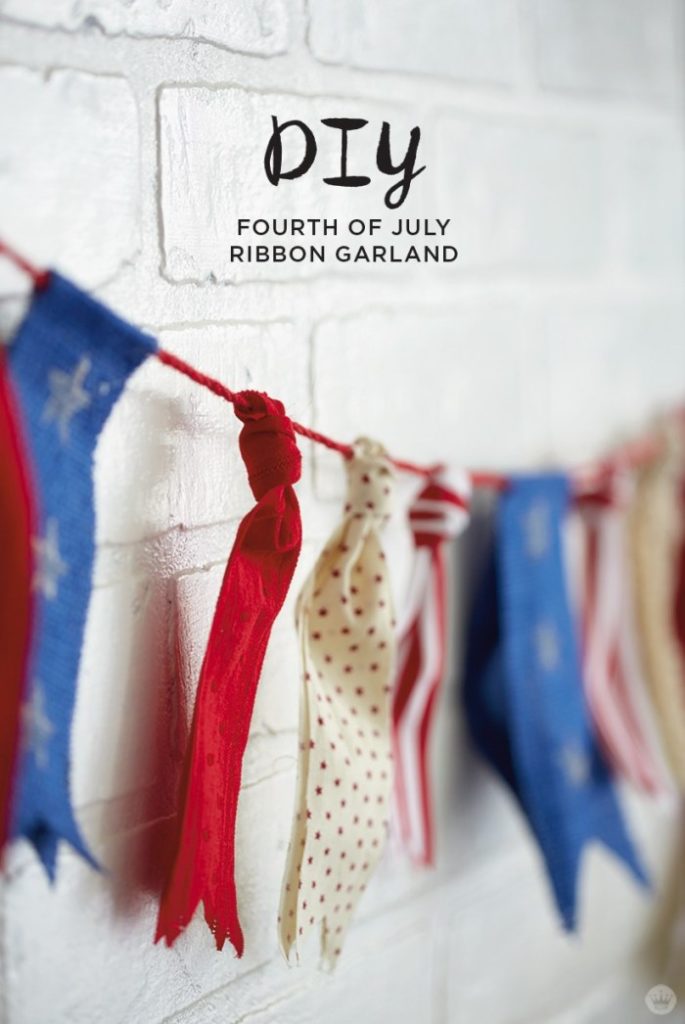 4th of july ribbons hanging off thread against white wall
