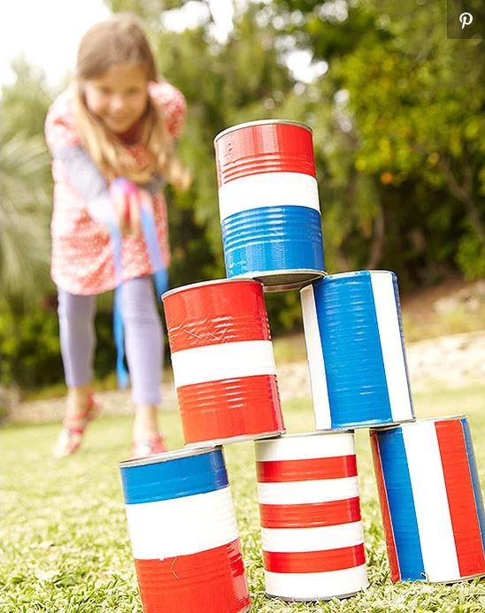 little girl playing 4th of july game with piled cans