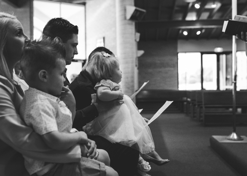 parents holding children in church baptism pictures