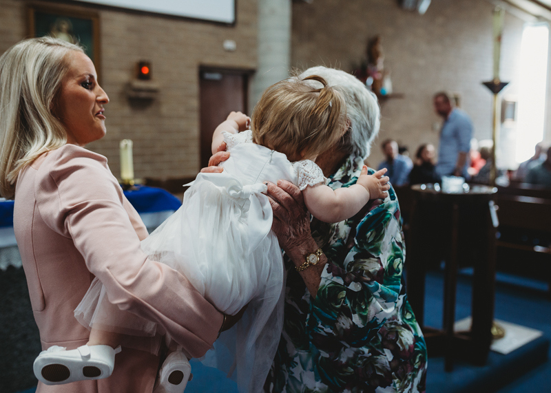 grandmother kissing the baby at baptism