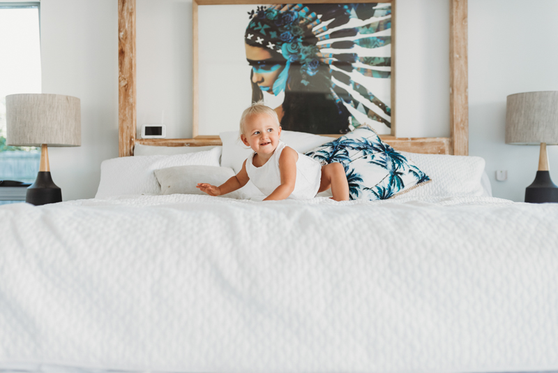 toddler playing in bed during maternity photo shoot