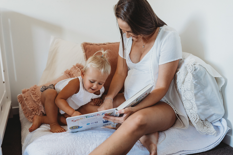 toddler and mother reading a book
