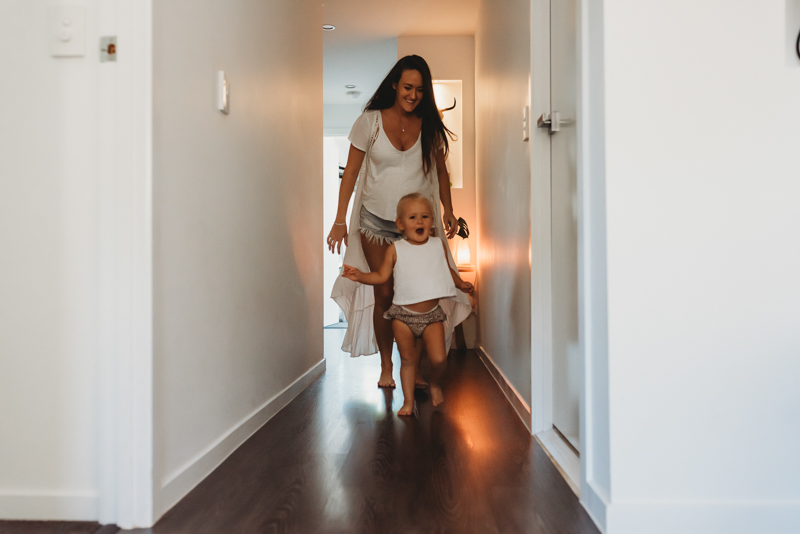 toddler and mom walking down hallway