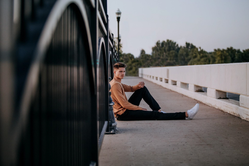male pose sitting on the bridge