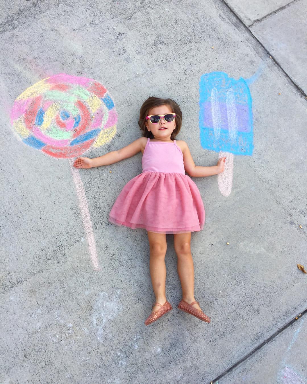 chalk photography of little girl with lollipop drawings