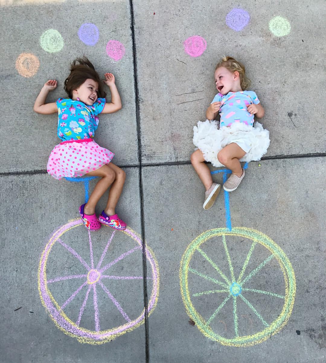 little girls having fun with sidewalk chalk art drawings