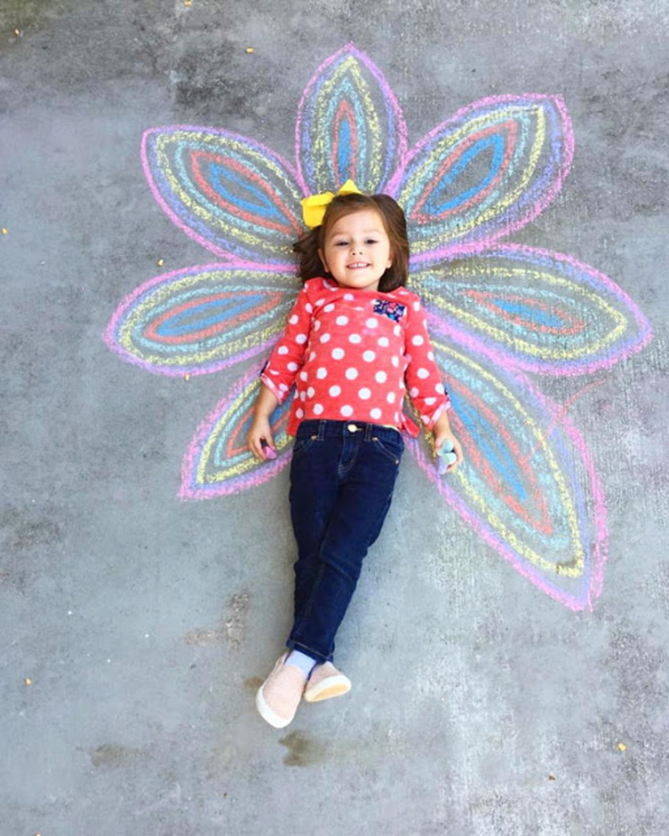 happy girl with chalk flower drawing