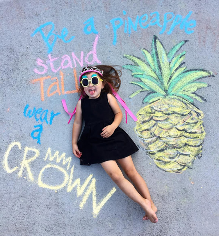 sidewalk chalk picture of pineapple and little girl