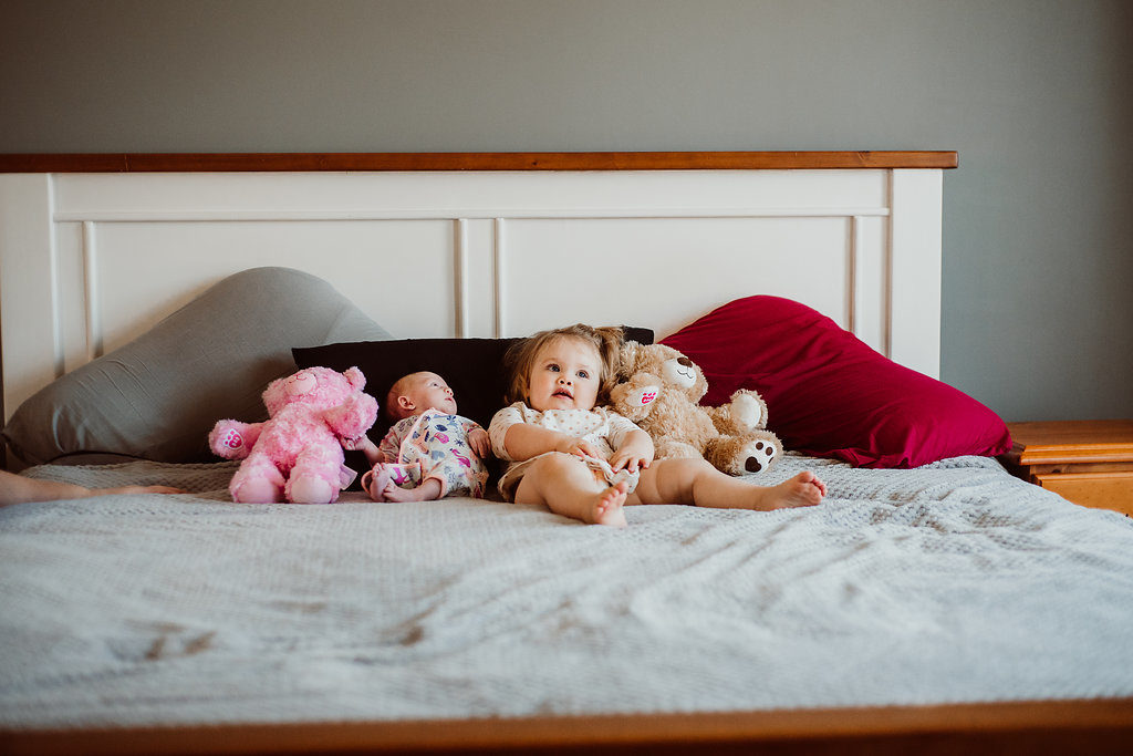  beautiful photo of toddler and newborn in bed