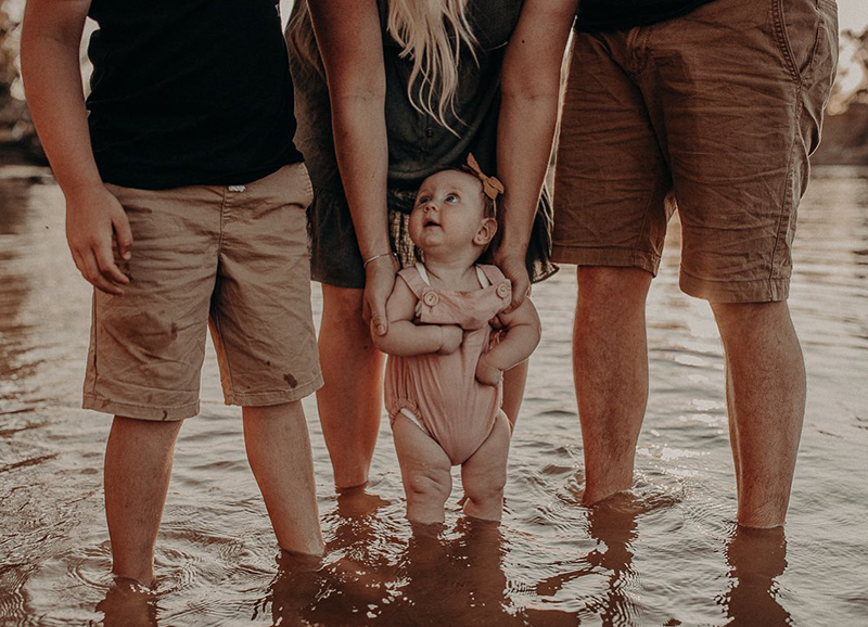 adults holding little girl
