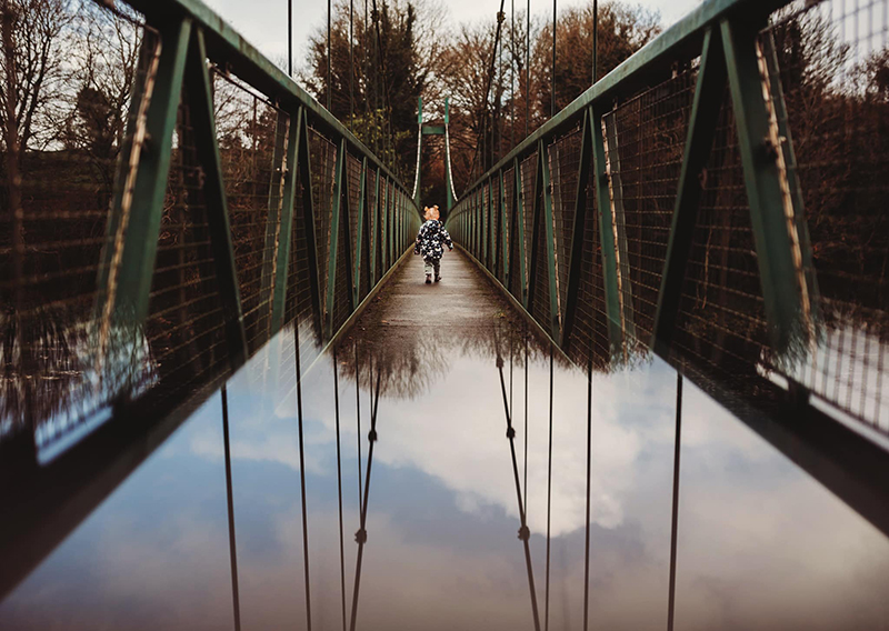 faceless portrait of kid walking on bridge 