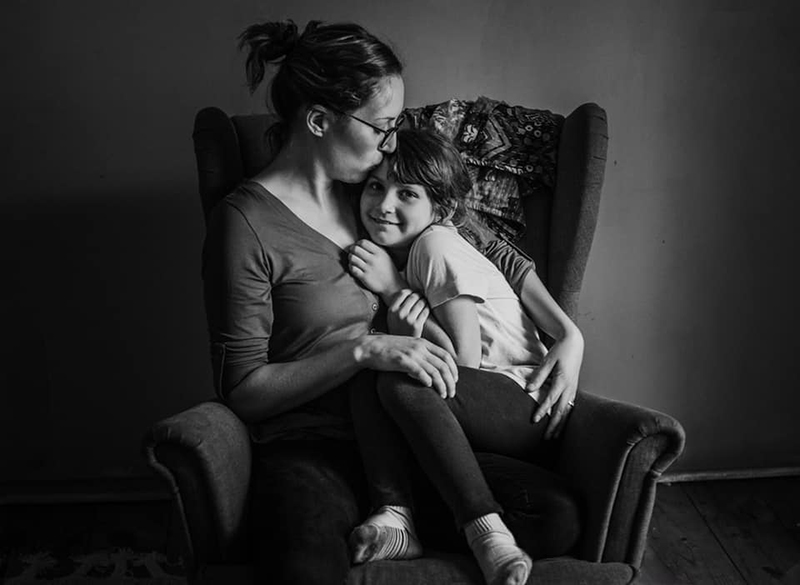 dark and moody photo of a mother and son in an armchair