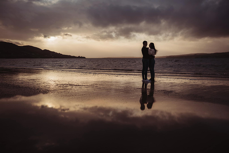  moody sunset silhouette picture of a couple at the beach 
