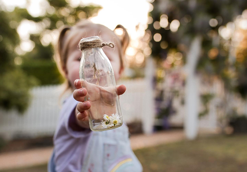  faceless pic of little girl handing a bottle
