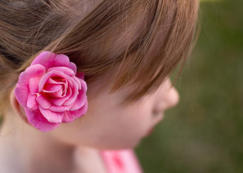 pink photo of little girl with flower in her hair