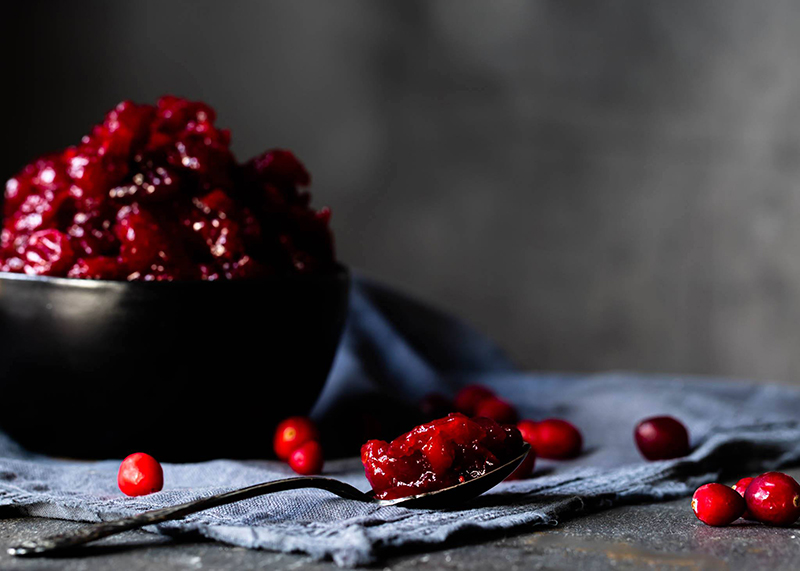 red fruits on spoon with dark background