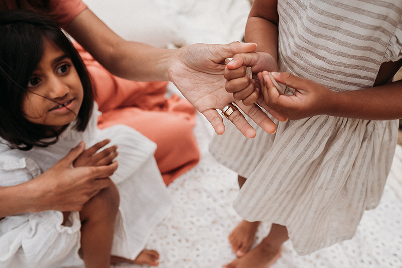 mother holding daughter’s hand with hands in focus