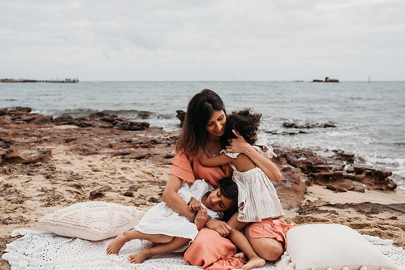 motherhood session of woman with two kids by the sea