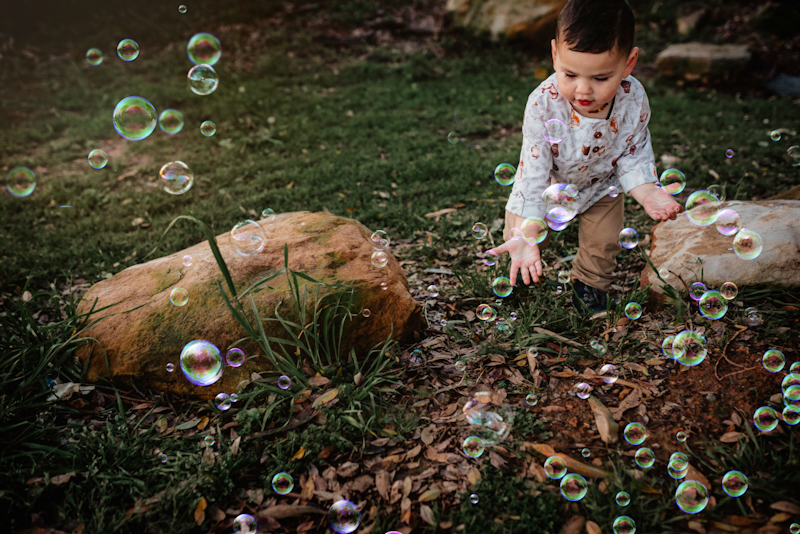 little boy playing in bubble photo