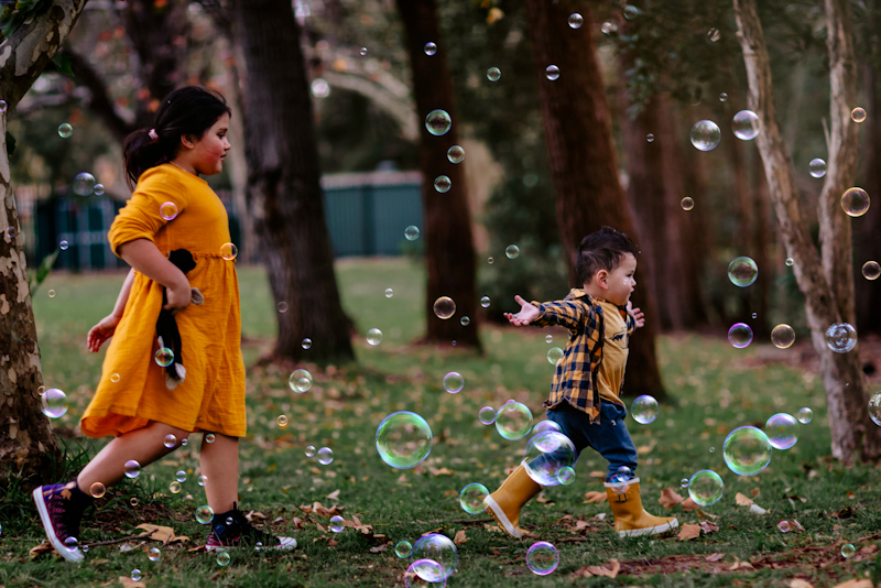 bubble photography of toddler boy chasing bubbles