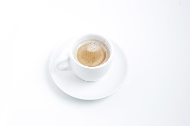  photography of a white cup of foamy coffee